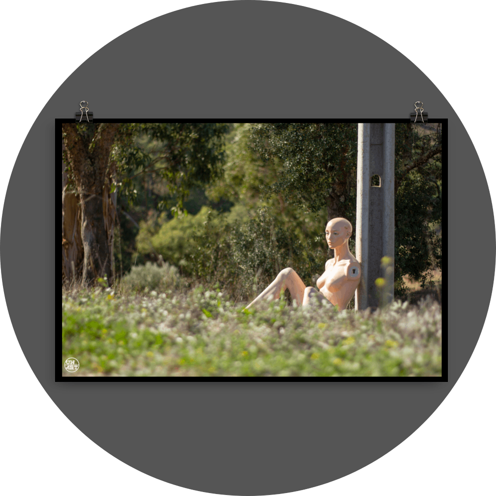 un4rt - almost human gallery poster mockup picture with a mannequin sitting outdoor during summer. the model leans against a concrete pole.