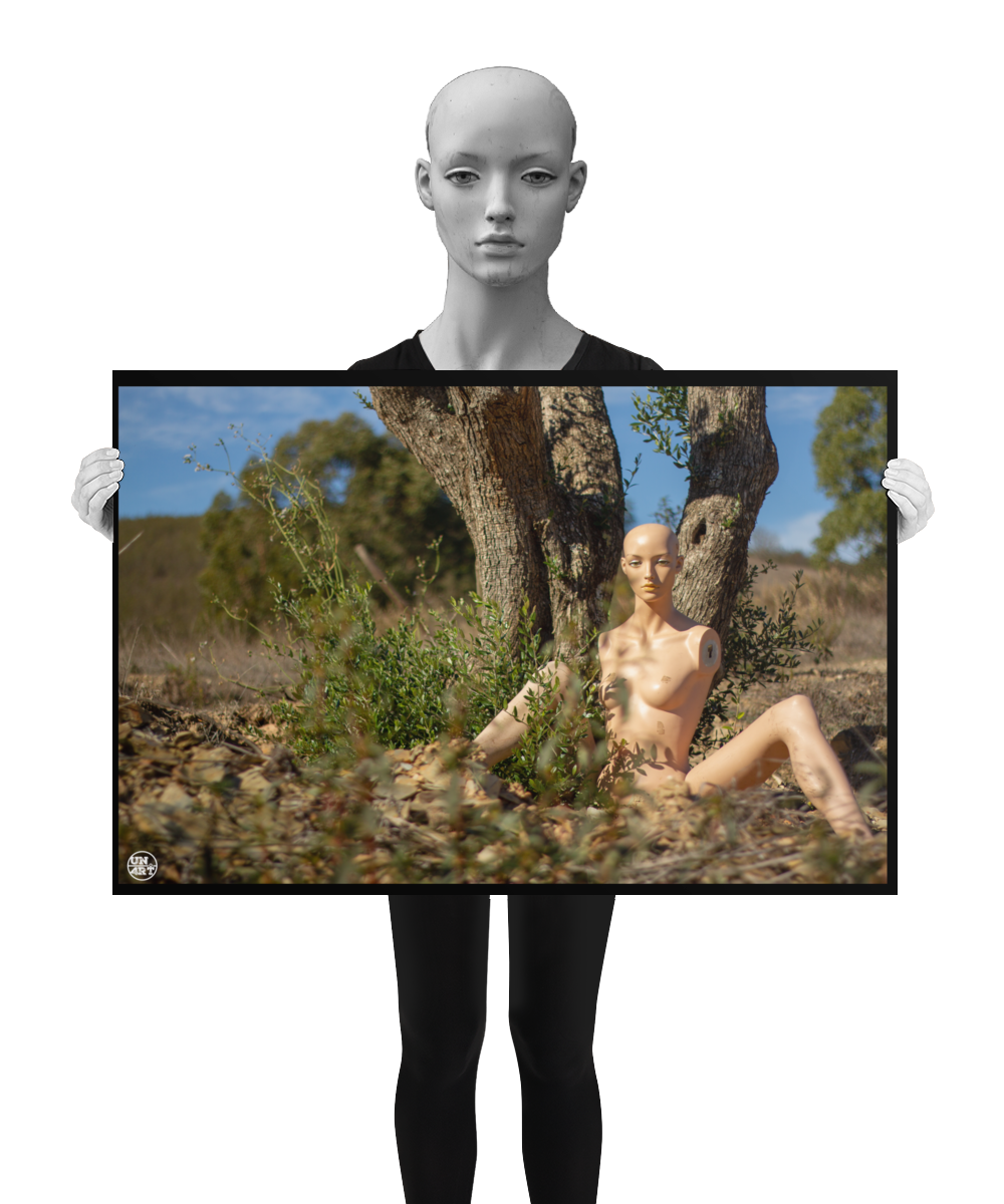 un4rt - almost human gallery poster mockup picture with a mannequin sitting outdoor in front of an old olive tree trunk. the poster is held by a mannequin.