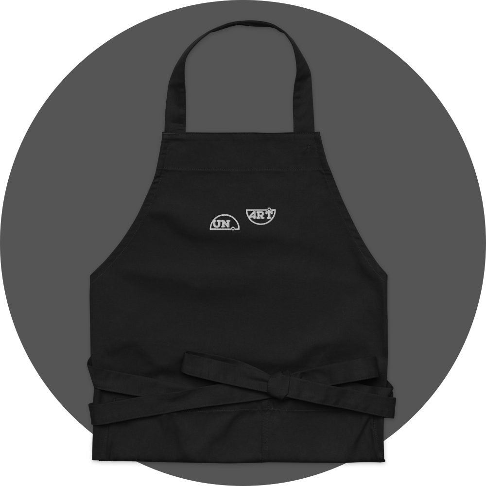 un4rt - the images shows a black apron with white embroidery of a splitted "UN4RT"-logo.