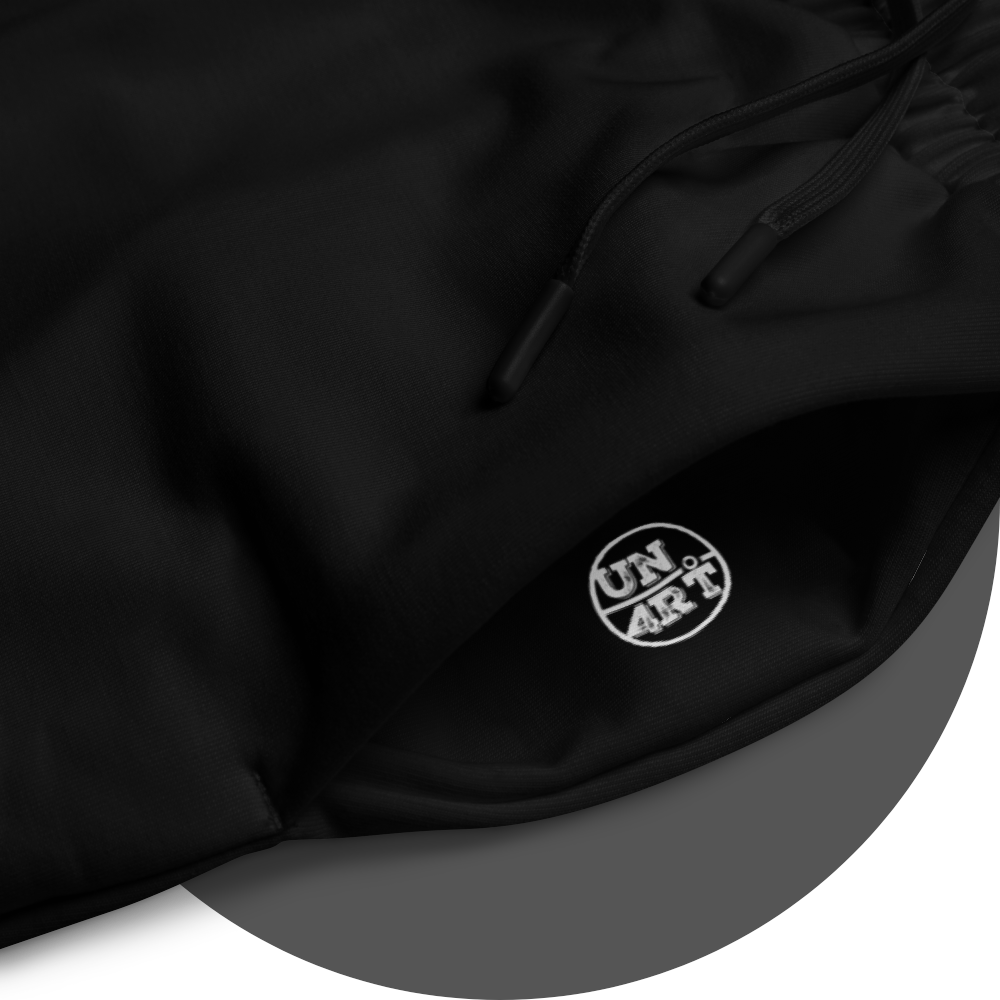un4rt - the image shows details of the left side pocket of a black jogger pant with a white print of the "UN4RT"-logo inside the pocket.