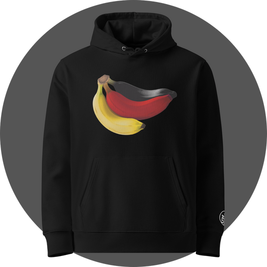 un4rt - the image shows the front of a black cotton hoodie with a print on the breast. the print shows three bananas colored in black, red and yellow. the left arm shows a part of a white embroidery of the "UN4RT"-logo.