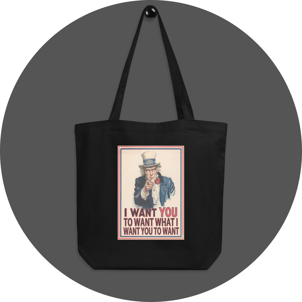 un4rt - the image shows a black cotton tote bag with an edited picture of a famous "uncle sam" painting where he is pointing at the viewer with his index finger. the picture is framed with red and blue lines. the text below the picture reads: "I want you to want what  want you to want".