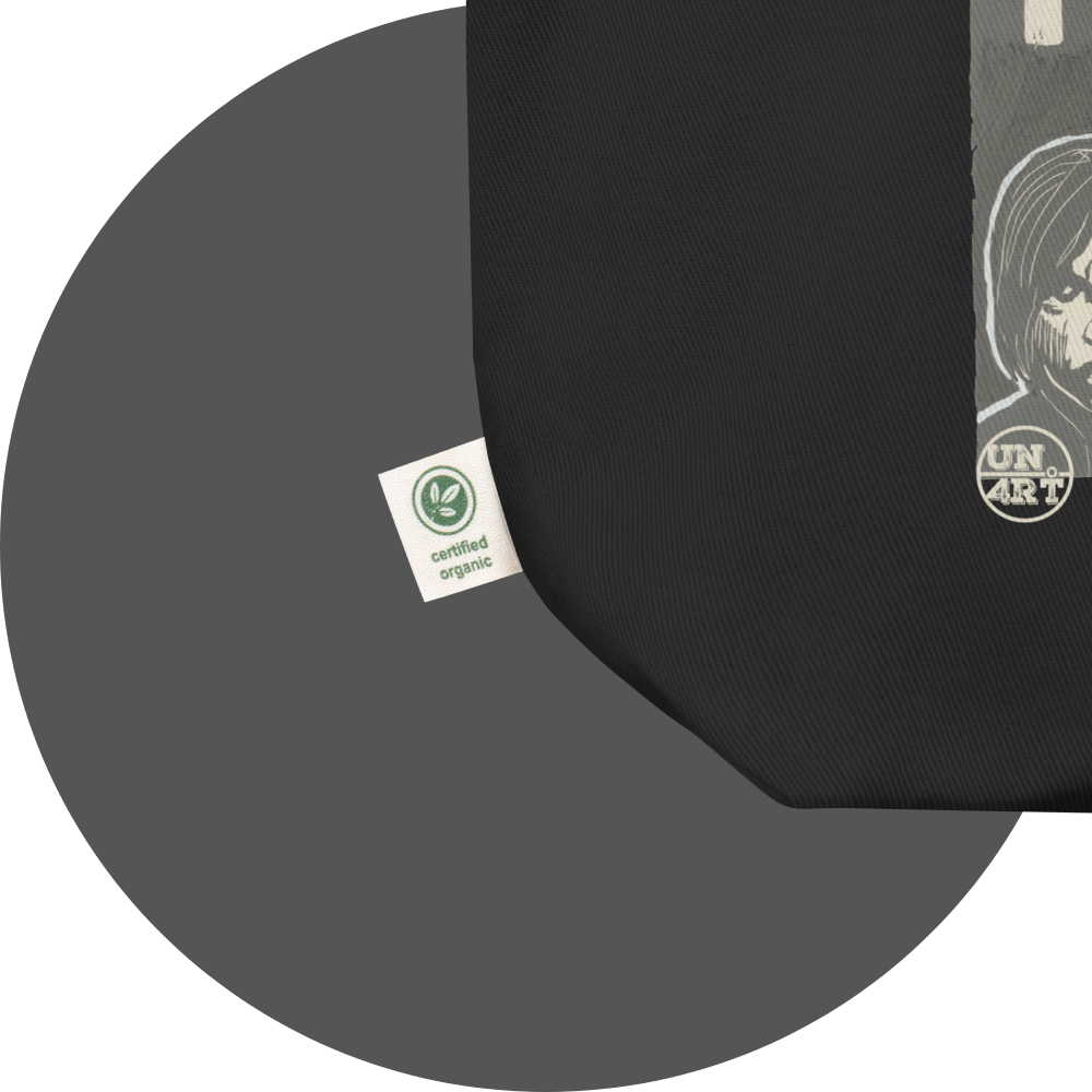 un4rt - the image shows details of a black cotton tote bag with parts of a print. a white label is attached to the tote bag. the print n the label reads: "certified rganic".