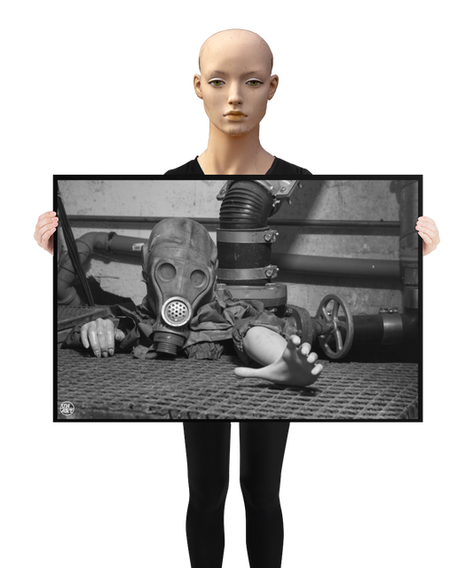 un4rt - a poster. black and white photographie of a mannequin wearing a gas mask. the mannequin stretches out one arm and reaches for help. the mannequin is crawling out of a hole in the ground. grif floor ground. pipes and a shut-off valve next to the mannequin. a mannequin is holding the poster.