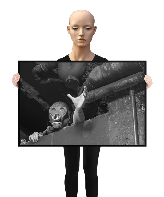 un4rt - a poster. black and white photographie of a mannequin wearing a gas mask. the mannequin stretches out one arm and reaches for help. the mannequin is stuck between a wall and a ceiling inside a cellar. waste water pipes above the mannequin. a mannequin is holding the poster.