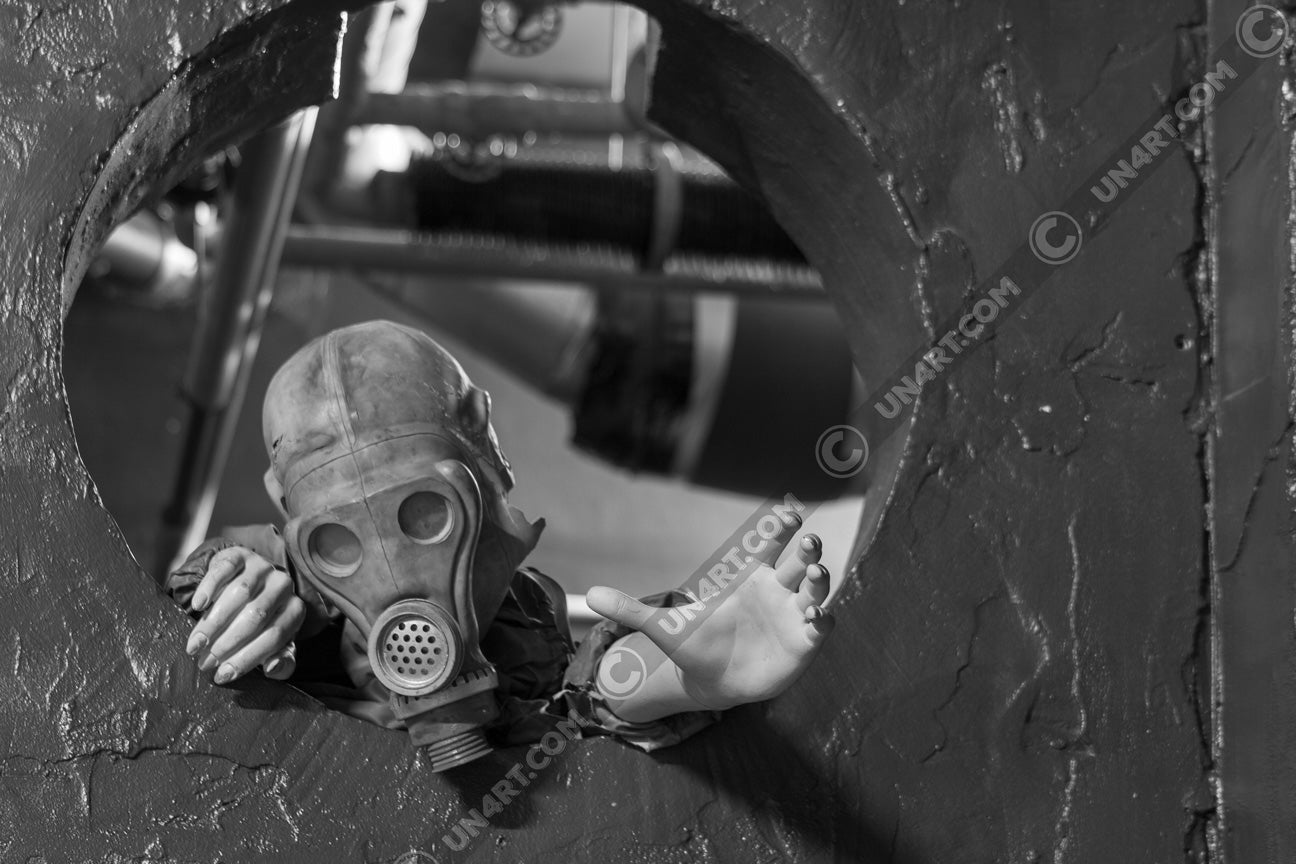 un4rt - black and white photographie of a mannequin wearing a gas mask and climbing through a round hole in a wall. the mannequin stretches out one arm and reaches for help.