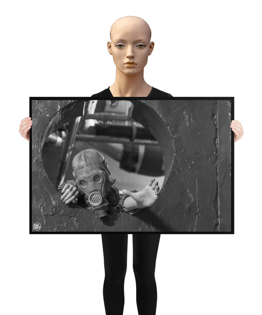 un4rt - a poster. black and white photographie of a mannequin wearing a gas mask and climbing through a round hole in a wall. the mannequin stretches out one arm and reaches for help. a mannequin is holding the poster.