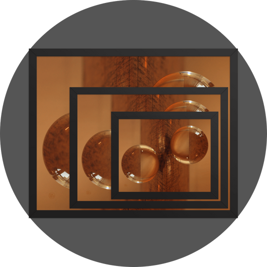 un4rt - the image shows 3 different sizes of the same photographie on top of each other. large size in the back, medium size in the middle and small size on top. the photographie is doubled and then mirrored. both photographies together create the final image. the photographie shows a glass ball on a wooden board. the wooden board is reflecting inside the glasball. the colors range from light brown to orange.