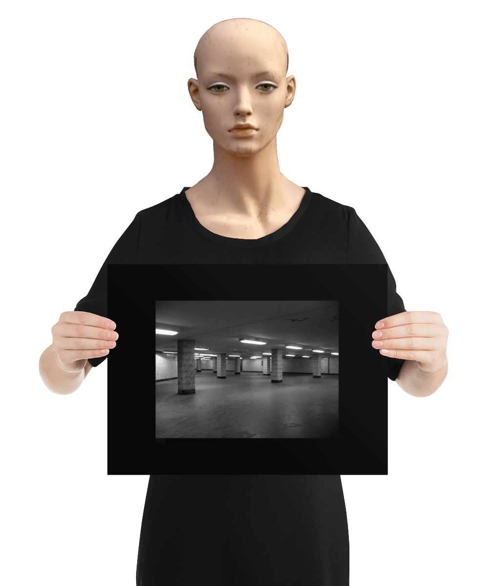 un4rt - a black and white photographie of a former underground trespas that once was part of the train station "alexanderplatz in berlin. tiled square columns support the ceiling. graffities on the columns and the ceiling. the image is held by a mannequin.