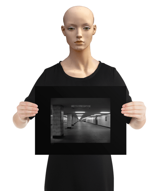un4rt - a black and white photographie of a former underground trespas that once was part of the train station "alexanderplatz in berlin. tiled square columns support the ceiling. a closed door on the right side. one light on the ceiling does´t work. the image is held by a mannequin.