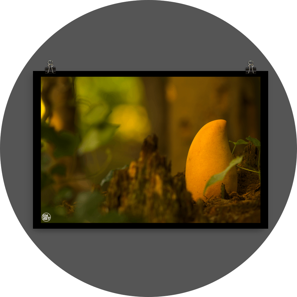 un4rt - photographie of a yellow mango in a forest. the mango is placed on top of a rotten tree trunk. some ivy around the mango. blurry and defocused background.