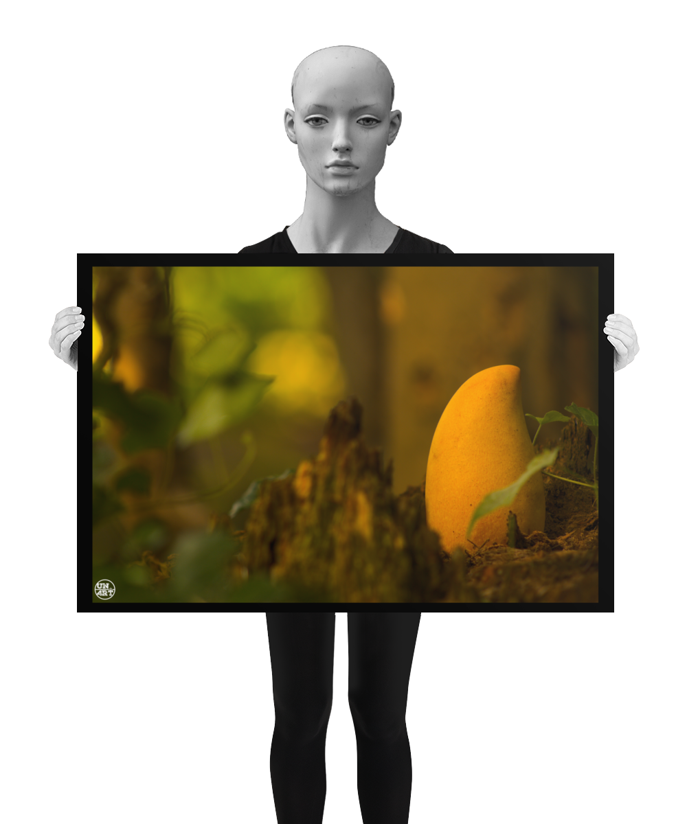 un4rt - photographie of a yellow mango in a forest. the mango is placed on top of a rotten tree trunk. some ivy around the mango. blurry and defocused background. the poster is presented by a mannequin in black and white.
