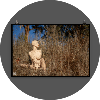 un4rt - almost human gallery poster mockup picture with a mannequin sitting outdoor in between very high and dried brown gras. some trees and blue sky in the background.