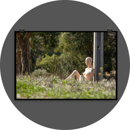 un4rt - almost human gallery poster mockup picture with a mannequin sitting outdoor during summer. the model leans against a concrete pole. 
