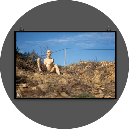 un4rt - almost human gallery poster mockup picture with a mannequin sitting outdoor on dry land in between brown grass. blue sky and a power line in the backround.