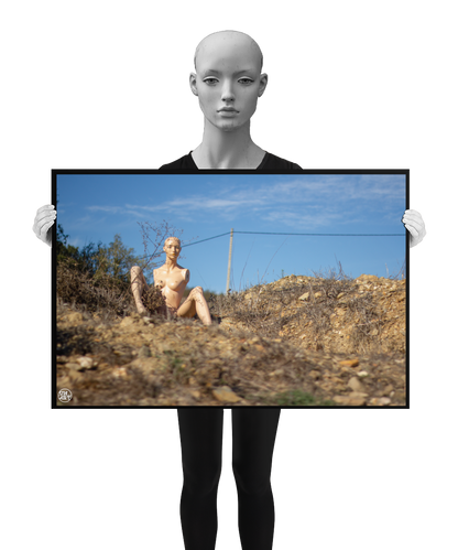 un4rt - almost human gallery poster mockup picture with a mannequin sitting outdoor on dry land in between brown grass. blue sky and a power line in the backround.
