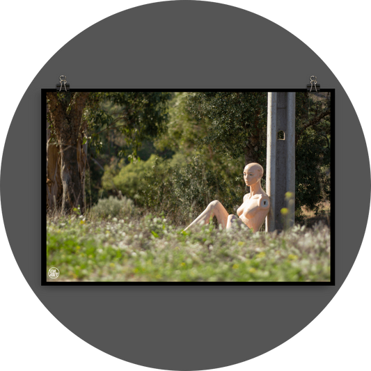 un4rt - almost human gallery poster mockup picture with a mannequin sitting outdoor during summer. the model leans against a concrete pole. 