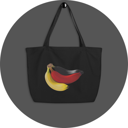 un4rt - the image shows one side of a black cotton tote bag with a big print on it. the print shows three bananas colored in black, red and yellow.