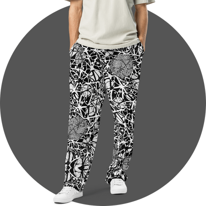 UN4RT black and white all-over print jogger pants, bold abstract web and dot pattern with organic circular forms, tapered fit, grey circular background
