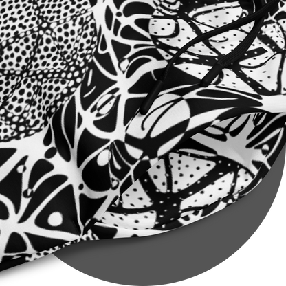 UN4RT brainbubbles all-over-print jogger detail – circular close-up of white fabric showing dense black organic network pattern of curved lines, stippled dot cluster circles and cell-like enclosed forms with fine line details, black drawstrings visible at waistband.