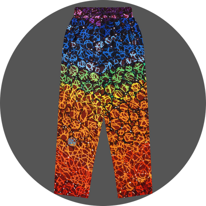 UN4RT chakra dots all-over-print jogger back flat – rainbow gradient sweatpants with anarchic graffiti lettering and circle motifs, vertical colour flow from deep purple and blue at waistband through green, yellow, orange to deep red at hem, scattered white rhinestone dots, small UN4RT logo at lower left leg, elasticated waistband.