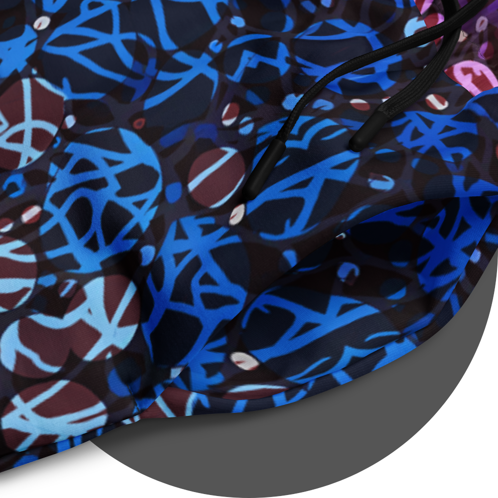 UN4RT chakra dots all-over-print jogger detail – circular close-up of deep blue fabric panel showing anarchic graffiti lettering and circle motifs in electric blue and light blue tones with scattered small white rhinestone dots, black drawstring visible.