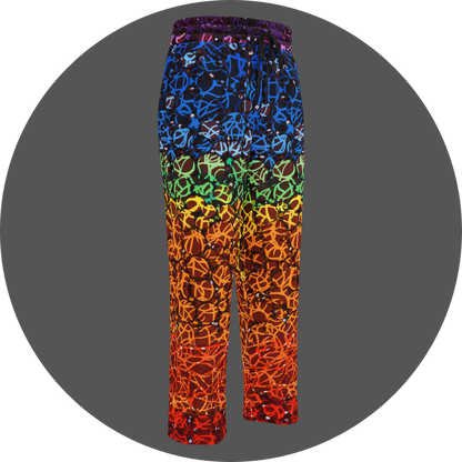 UN4RT chakra dots all-over-print jogging pants front right view – rainbow gradient sweatpants with anarchic graffiti lettering in blue, green, yellow and orange tones, scattered white rhinestone dots, elasticated drawstring waistband, straight leg cut.
