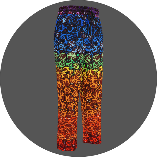 UN4RT chakra dots all-over-print jogging pants front right view – rainbow gradient sweatpants with anarchic graffiti lettering in blue, green, yellow and orange tones, scattered white rhinestone dots, elasticated drawstring waistband, straight leg cut.