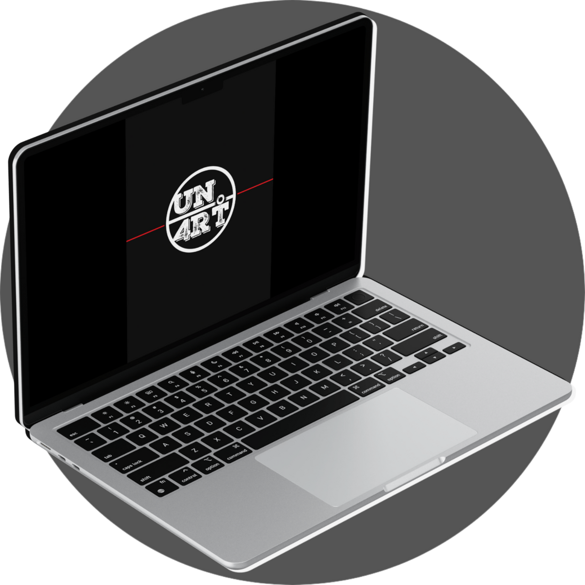 UN4RT Cadernos – collection mockup of a silver laptop in three-quarter angled view displaying the UN4RT circular badge logo in distressed white lettering bisected by a horizontal red line on a solid black screen, dark editorial brand identity digital collection mockup on a grey circular background
