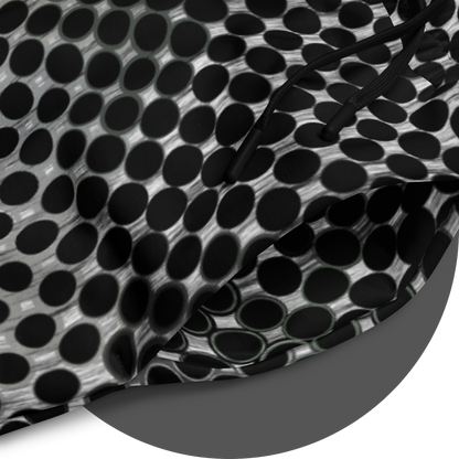 UN4RT doterium jogging pants fabric detail – circular close-up of all-over-print showing black circle dot pattern on white fabric with black drawstring visible, fine halftone gradient from solid to hollow ring forms.