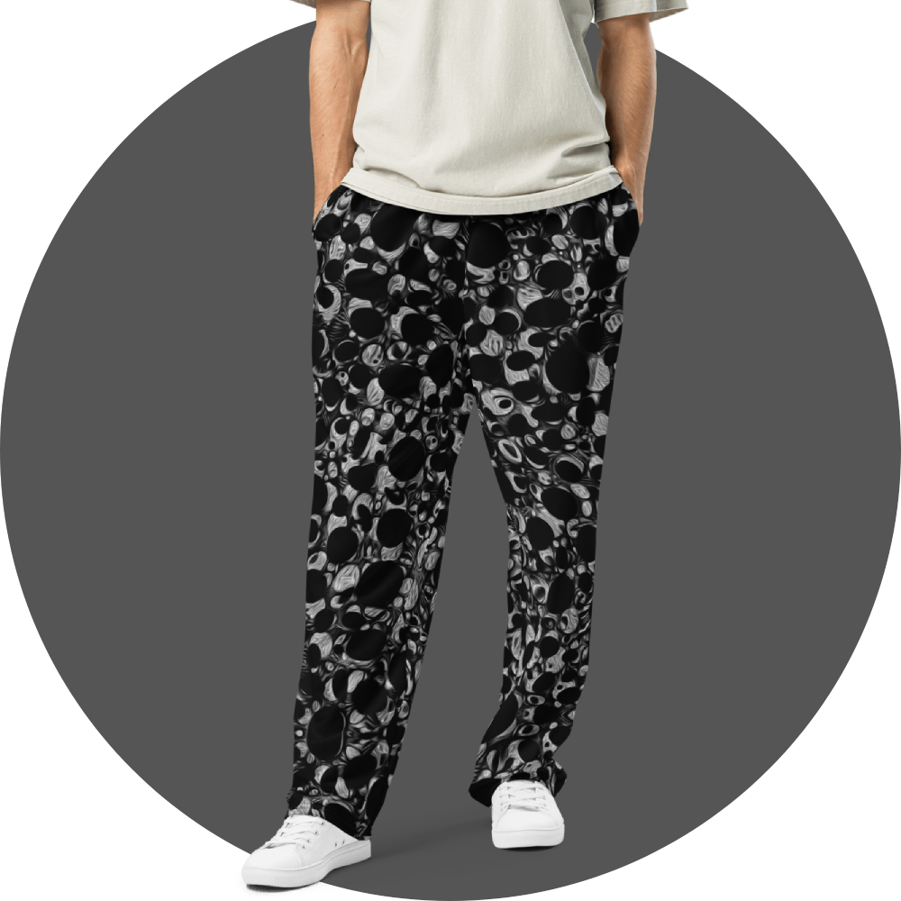 UN4RT black and grey all-over print jogger pants, dense repeating circular and organic bubble pattern in black and grey tones, straight fit, grey circular background.