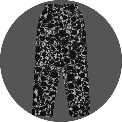UN4RT eyesolation all-over-print jogging pants back flat – black sweatpants with dense abstract pattern of black organic blob shapes and grey brushstroke texture, elasticated waistband, small UN4RT logo at lower leg, subtle eye motif visible in print.