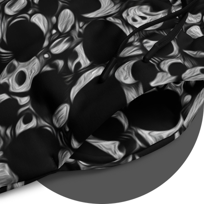 UN4RT eyesolation jogger detail – circular close-up of all-over-print showing dense abstract pattern of black organic blob shapes with grey brushstroke texture on black fabric, black drawstring visible at waistband opening.