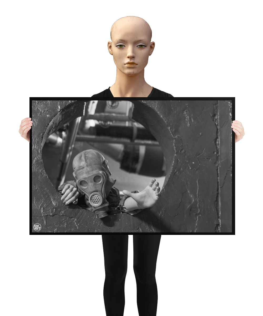 un4rt - a poster. black and white photographie of a mannequin wearing a gas mask and climbing through a round hole in a wall. the mannequin stretches out one arm and reaches for help. a mannequin is holding the poster.