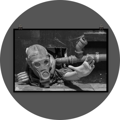 un4rt - black and white photographie of a mannequin wearing a gas mask. the mannequin stretches out one arm and reaches for help. the body is stuck inside a small hole in a wall. unused blackwater pipes next to the mannequin.