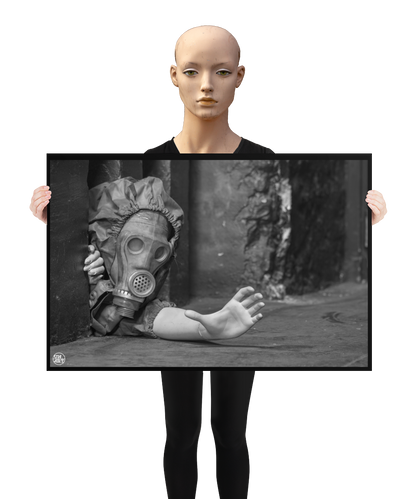 un4rt - a poster. black and white photographie of a mannequin wearing a gas mask. the mannequin stretches out one arm and reaches for help. the mannequin is crawling out of a tiny hole in the wall, directly on the floor. a mannequin is holding the poster.