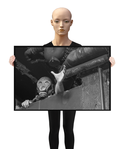 un4rt - a poster. black and white photographie of a mannequin wearing a gas mask. the mannequin stretches out one arm and reaches for help. the mannequin is stuck between a wall and a ceiling inside a cellar. waste water pipes above the mannequin. a mannequin is holding the poster.