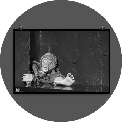 un4rt - black and white photographie of a mannequin wearing a gas mask and forcing its way through a tiny gap between two walls. the mannequing stretches out one arm and reaches for help. 