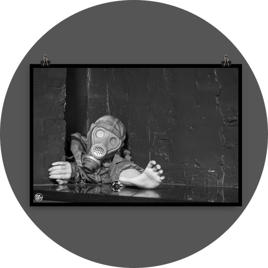 un4rt - black and white photographie of a mannequin wearing a gas mask and forcing its way through a tiny gap between two walls. the mannequing stretches out one arm and reaches for help. 