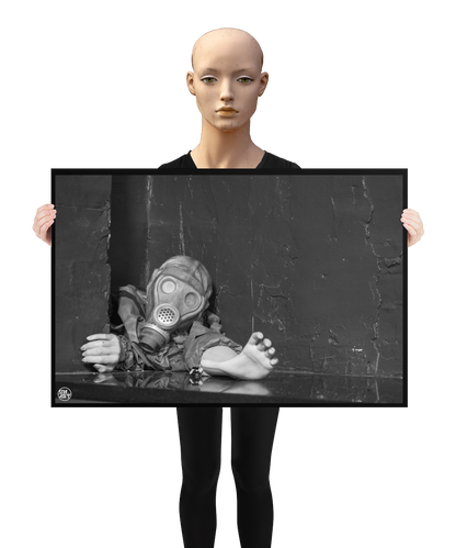 un4rt - a poster. black and white photographie of a mannequin wearing a gas mask and forcing its way through a tiny gap between two walls. the mannequing stretches out one arm and reaches for help. a mannequin is holding the poster.