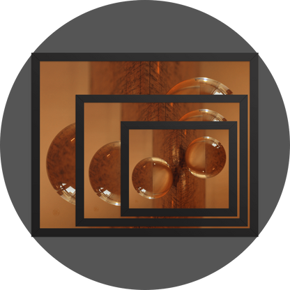 un4rt - the image shows 3 different sizes of the same photographie on top of each other. large size in the back, medium size in the middle and small size on top. the photographie is doubled and then mirrored. both photographies together create the final image. the photographie shows a glass ball on a wooden board. the wooden board is reflecting inside the glasball. the colors range from light brown to orange.