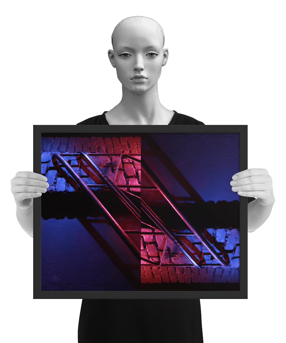 un4rt - the photographie is doubled and then mirrored. both photographies together create the final image. the image shows a brick wall and a wall with a handrail. the illumination changes from red to blue. the image is framed and presented by a mannequin in black and white.