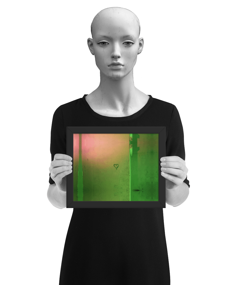 un4rt - the photographie shows a wall that is colored in green, ochre and pink. the symbol of a heart is painted on the wall. the image is framed and presented by a mannequin in black and white.