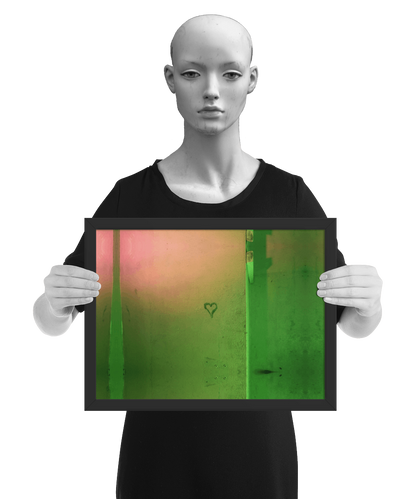 un4rt - the photographie shows a wall that is colored in green, ochre and pink. the symbol of a heart is painted on the wall. the image is framed and presented by a mannequin in black and white.