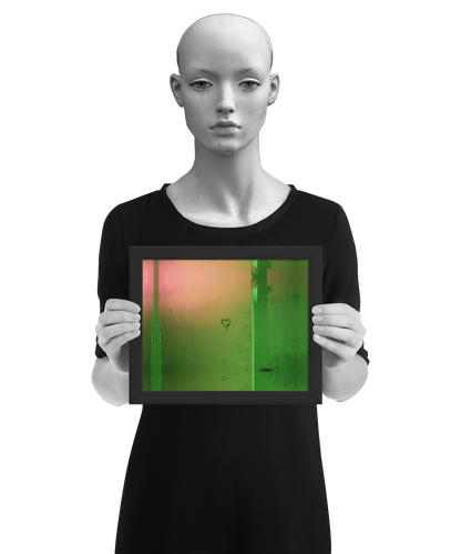 un4rt - the photographie shows a wall that is colored in green, ochre and pink. the symbol of a heart is painted on the wall. the image is framed and presented by a mannequin in black and white.