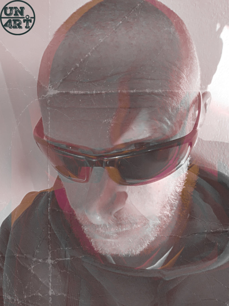 UN4RT imaginarium – close-up self-portrait of MARK ... with a short beard and dark sports sunglasses seen through a crumpled transparent plastic sheet creating distorted fragmented reflections in warm pale pink and amber tones, dark experimental fine art self-portrait photography.
