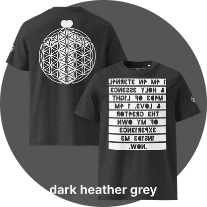 UN4RT dark heather grey organic cotton t-shirt shown from the front and back, front features a large mirrored text artwork on a white rectangular background with reversed dark grey bold lettering reading "i am an eternal & holy essence, made of light & love. i am the creator of my own experience inside me. now.", back features a large white flower of life sacred geometry circle with a white heart shape above it, small circular brand logo visible on both left sleeves.
