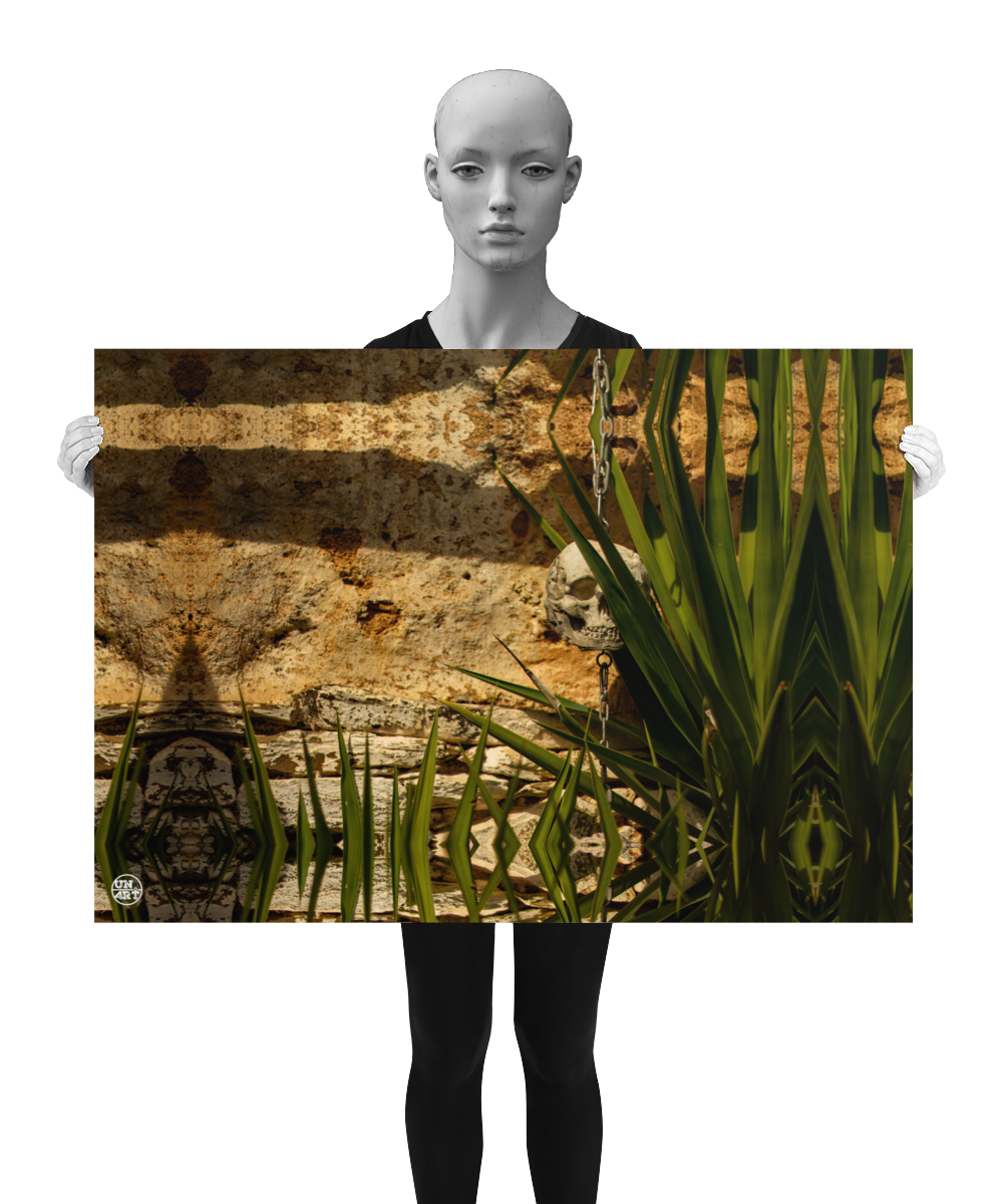 un4rt - a poster.  a mirror-framed photographie of a tiny skull hanging on a chain in front of an old wall. some parts of the skull are covered by a yucca. the poster is presented by a model in black and white.