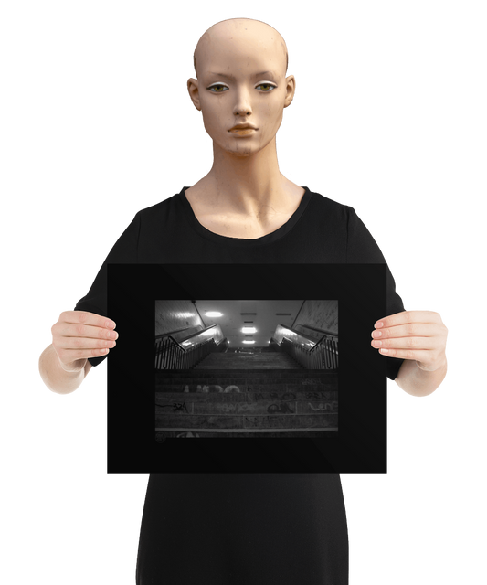 un4rt - a black and white photographie of a former underground trespas that once was part of the train station "alexanderplatz in berlin. stairway. graffities on the stairs and the walls. the image is held by a mannequin.