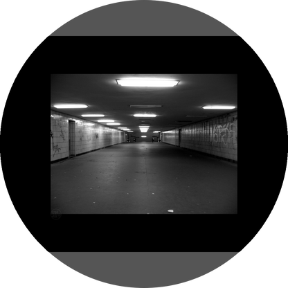 un4rt - a black and white photographie of a former underground trespas that once was part of the train station "alexanderplatz" in berlin. graffities on the walls, trash on the ground.
